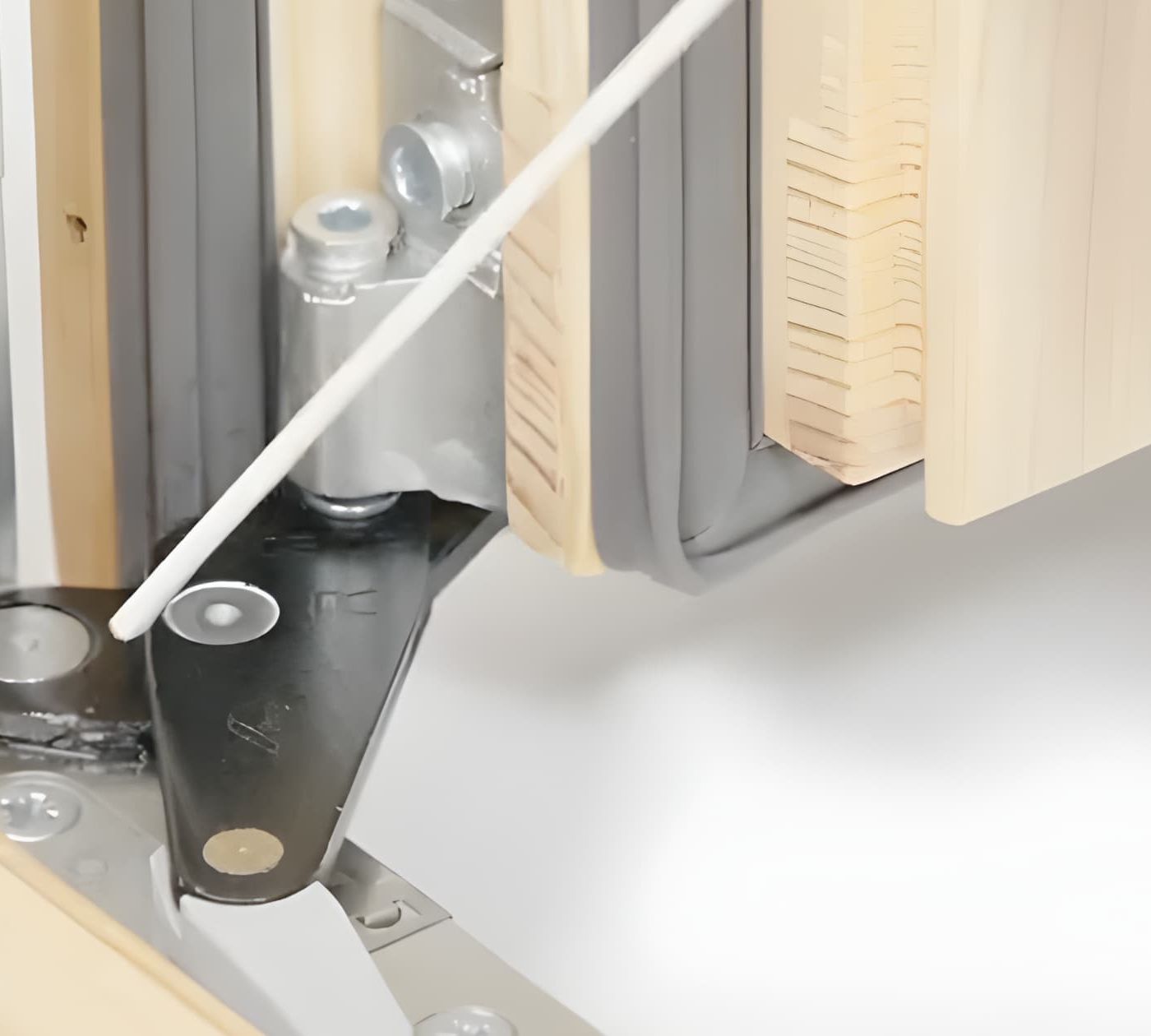 Smarowanie zawiasu ukrytego w systemie Roto NXC przy pomocy aplikatora – pielęgnacja okuć w oknie drewnianym.